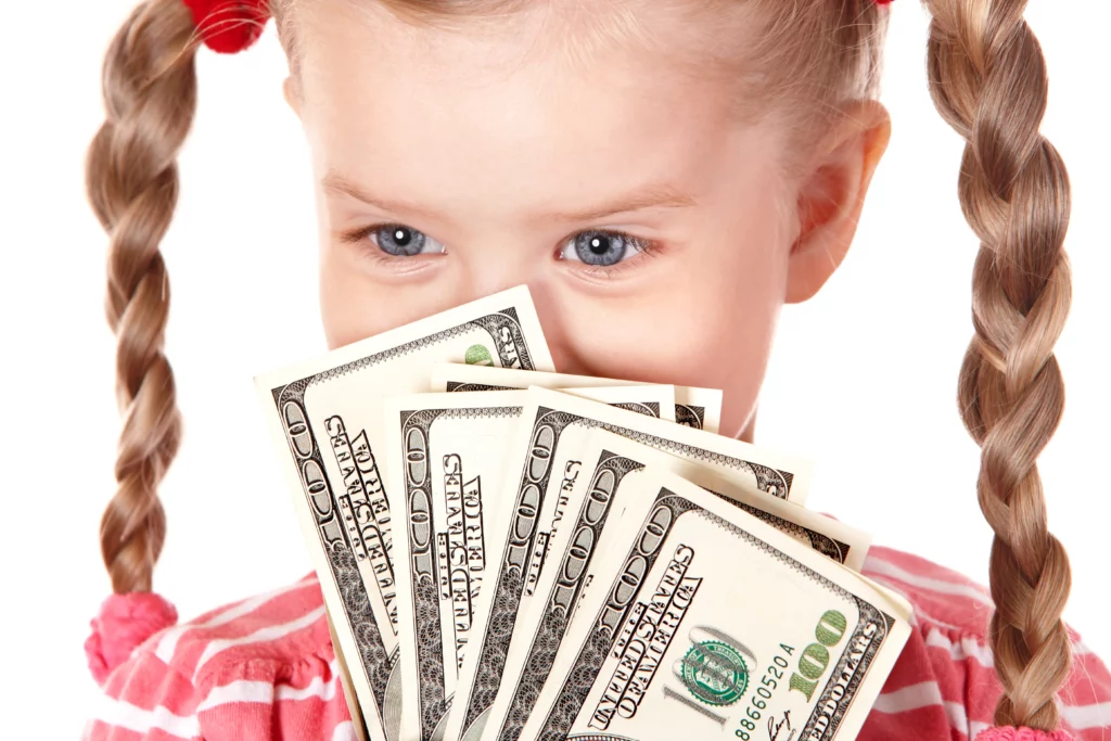 Little girl with pigtails holding cash to her face