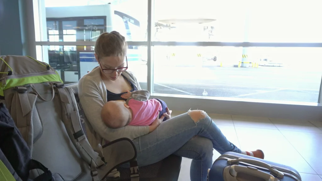 woman breastfeeding baby in airport