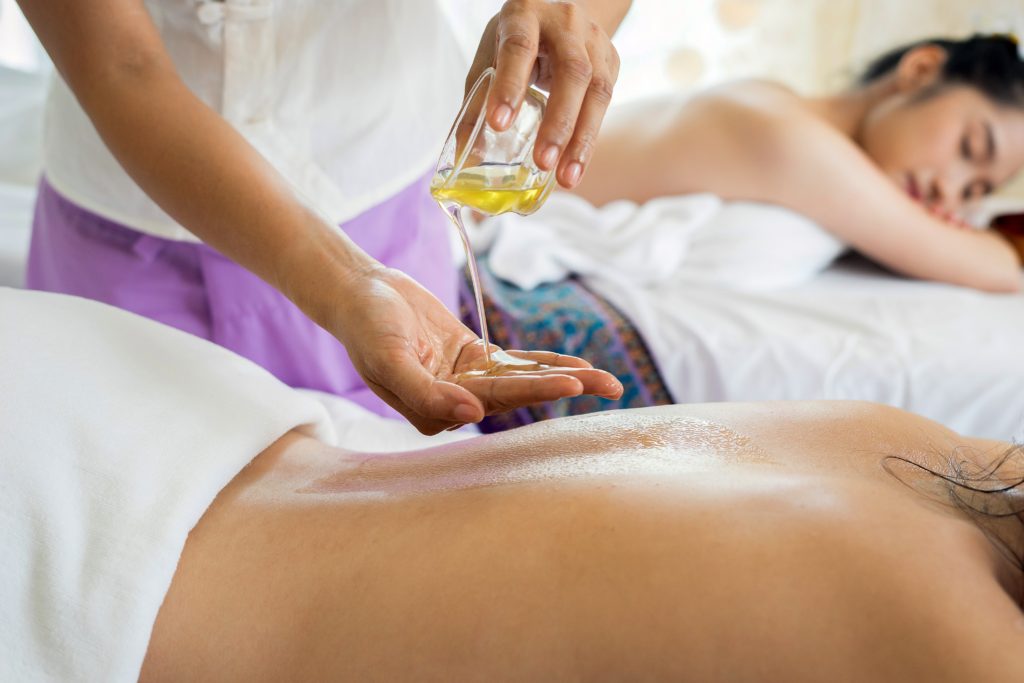 masseuse giving massages and pouring oil