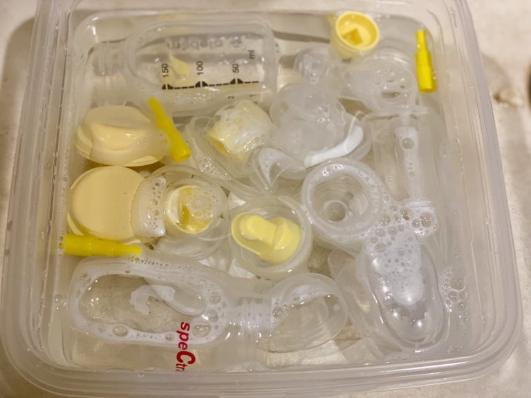 Breast pump parts being cleaned in wash basin with soap and water