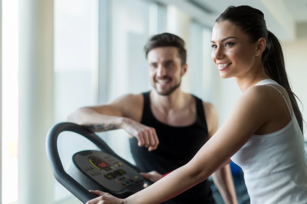 Girl on treadmill while partner is standing next to her