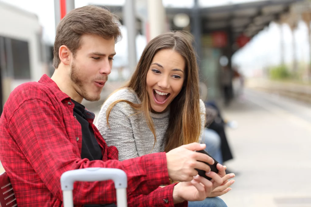 couple looking at phone in train station
